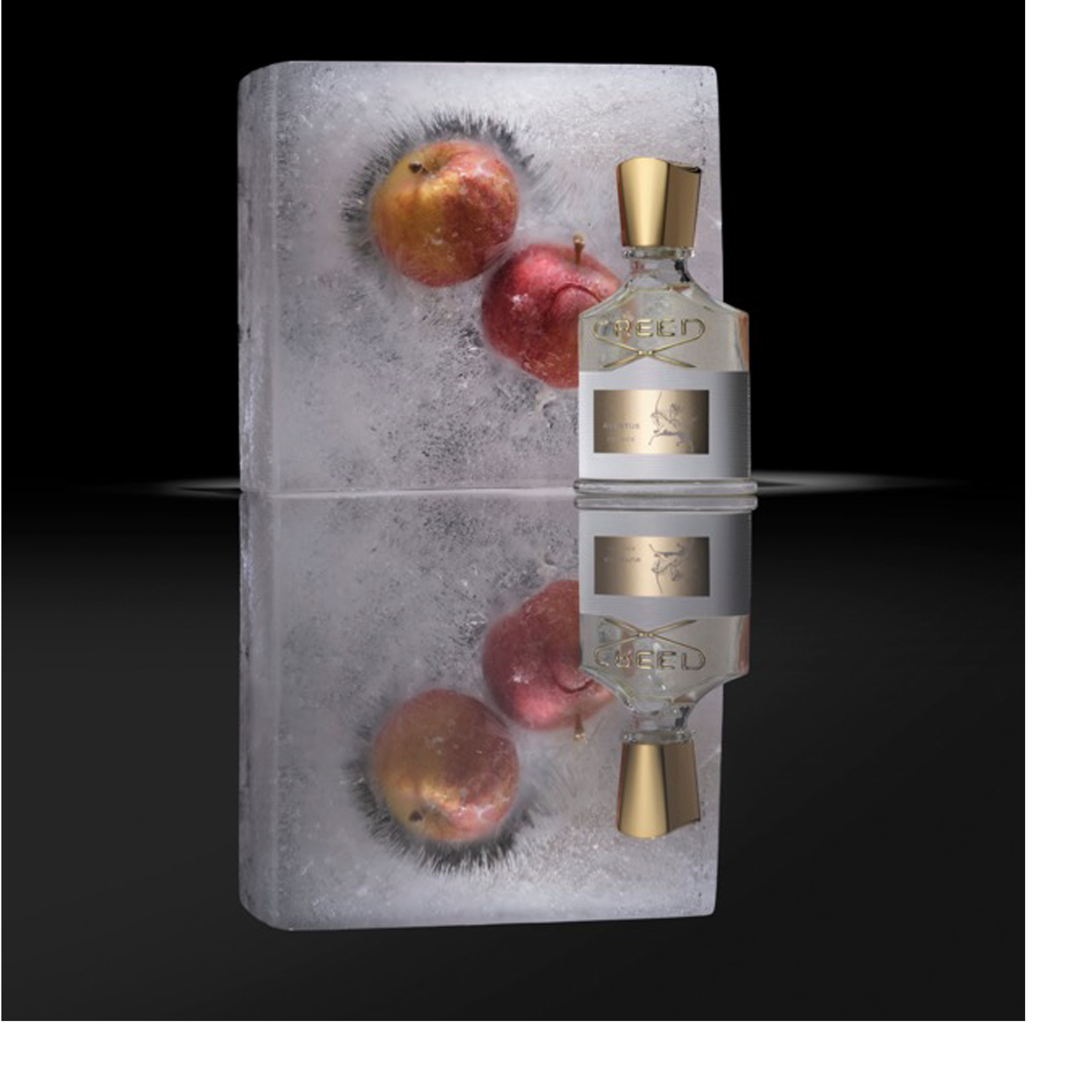 A clear perfume bottle with a gold cap and label is positioned next to a rectangular block of ice that has three red and yellow apples frozen inside it, with both items and their reflections visible on a dark surface, and the bottles label reads CREED AVENTUS.