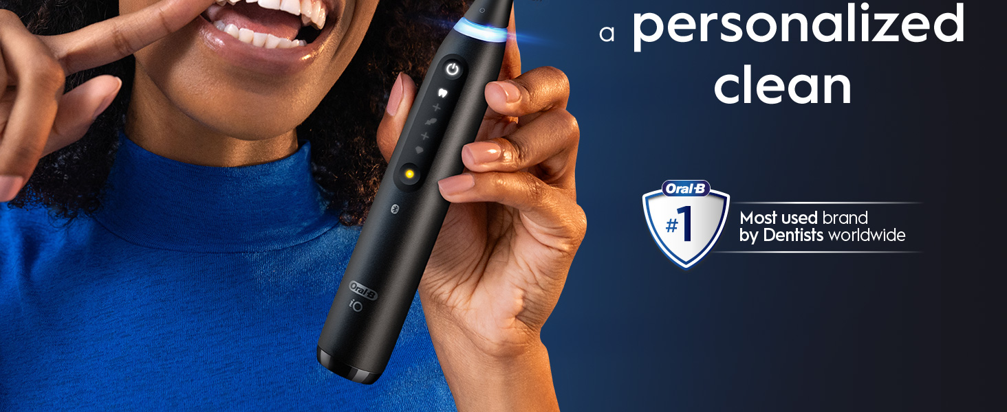 A person holding a black Oral-B iO electric toothbrush and showing their teeth with text a personalized clean Oral-B #1 Most used brand by Dentists worldwide.