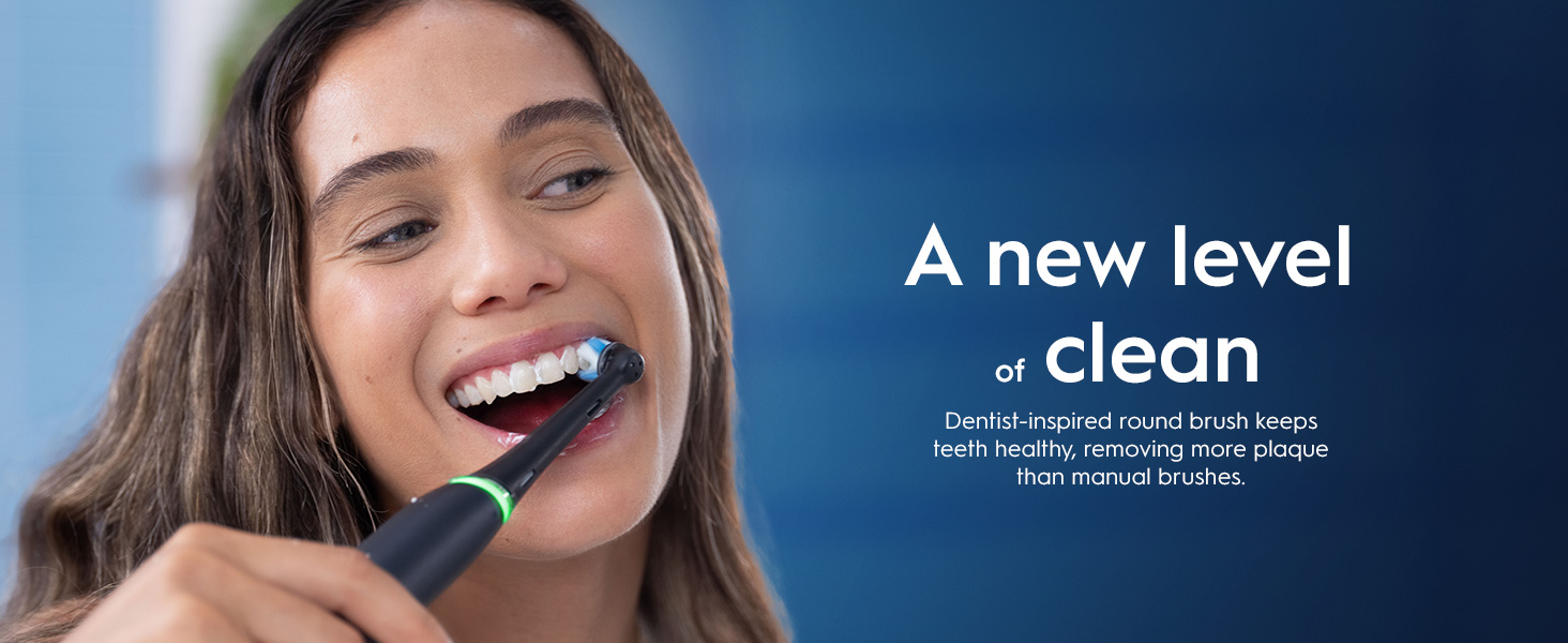 A woman smiles while brushing her teeth with an electric toothbrush; the text says A new level of clean Dentist-inspired round brush keeps teeth healthy, removing more plaque than manual brushes.