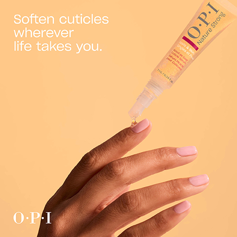 A hand with light pink painted nails is shown receiving a drop of glittery OPI cuticle serum from a tube onto its index finger, with the visible text Soften cuticles wherever life takes you, OPI Nature Strong, Nails & Skin, Ongles et Peau, Good as Gold, Cuticle Serum, Sérum Miracle, pour Cuticules, 7 mL / 0.24 fl. oz., and OPI.