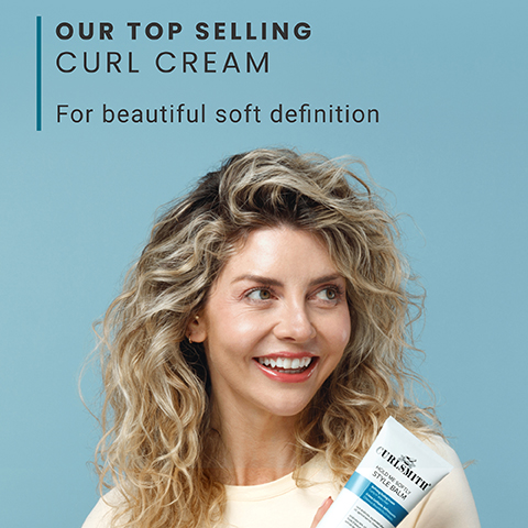 A smiling woman with blonde curly hair looks to the right, holding a white tube of hair product, with the text OUR TOP SELLING CURL CREAM For beautiful soft definition CURLSMITH HOLD ME SOFTLY STYLE BALM visible.