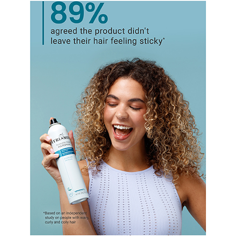 A smiling woman with curly hair holds a white Curlsmith Flawless Finish Hairspray can against a blue background, with text above reading 89% agreed the product didnt leave their hair feeling sticky*, and text below stating *Based on an independent study on people with wavy, curly and coily hair.