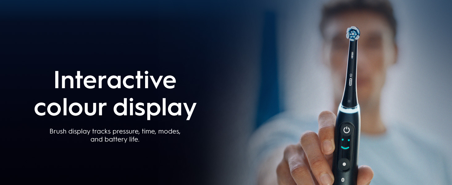 .A person holds the toothbrush in front of them showing the interactive colour display