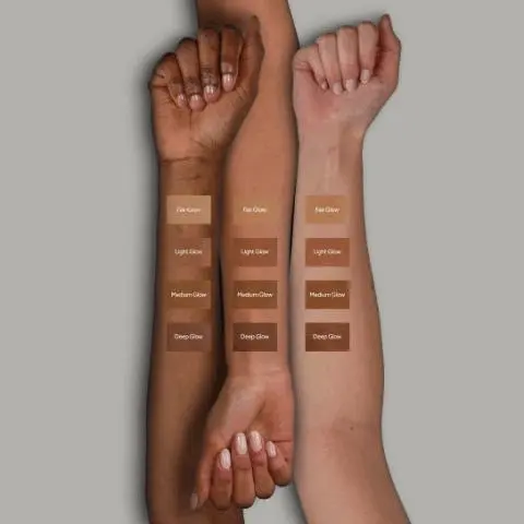 Image 1 - Three arms with diverse skin tones, from dark to light, are shown with four swatches of foundation on each, labeled Fair Glow, Light Glow, Medium Glow, and Deep Glow. Image 2 - The image displays multiple black and gold compacts with golden-brown bronzer powder, some open to reveal the product with the No7 logo embossed, arranged on a reflective surface against a gray background, with overlay text that reads: SOFT GLOW BRONZER, Warms your complexion for a sun-kissed finish, Silky, lightweight formula leaves skin looking naturally radiant, and Adds warmth and depth for a lasting soft glow.
