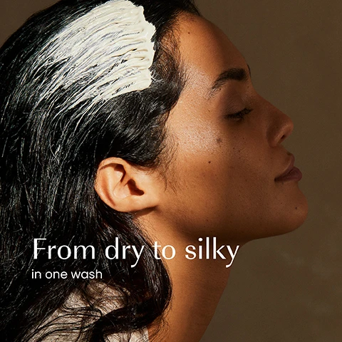Image 1 - A person with dark hair and closed eyes has a white hair product applied to their roots, with text that reads From dry to silky in one wash. Image 2 - A light beige, textured background with ripples displays the text: 98.63% NATURAL, HALAL, PARABENS & SILICONE FREE. Image 3 - The image shows a side-by-side comparison of two izil conditioner tubes, featuring the old white izil NOURISH NUTRICARE For Nourishing Conditioner packaging on the left and the new dark teal izil NUTRICARE ARGAN NOURISHING CONDITIONER NOURISH, SOFTEN & MOISTURISE packaging on the right, with the prominent text New Look. Same formula you love.