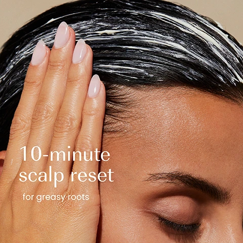 Image 1 - A person with dark hair has a white product applied to their roots while a hand with manicured nails touches their head, next to the text 10-minute scalp reset for greasy roots. Image 2 - A hand holds a light beige jar with a dark blue lid; the jar is labeled izil OIL CONTROL PRE-SHAMPOO CLAY MASK, detailing benefits as REMOVE PRODUCT BUILD-UP, MINIMISE OIL & PURIFY SCALP, with ingredients White Clay, Tapioca Starch, Eucalyptus Oil, also featuring MASQUE À LARGILE AVANT SHAMPOOING SÉBO-RÉGULATEUR and the Arabic text الماسك الطيني قبل الشامبو للتحكم في الزيوت; additional text on the image to the left states Removes product build-up, Purifies scalp, Minimises oil. Image 3 - An image displays two jars of izil Oil Control Pre-Shampoo Clay Mask side-by-side with the text New Look, Same formula you love; the old packaging on the left is a white jar with an orange label showing izil, 4 BALANCE, OIL CONTROL, PRE-SHAMPOO CLAY MASK, REDUCE PRE-SHAMPOO OIL & SEBUM, WITH CLAY, WOOD SPICE & EUCALYPTUS, FOR OILY, ACNE PRONE SCALP & HAIR, 100% NAT. & ORGANIC, MADE IN UAE, and the new packaging on the right is a translucent jar with a dark teal lid and cream label showing izil, OIL CONTROL, PRE-SHAMPOO CLAY MASK, REMOVE PRODUCT BUILD-UP, NORMALIZE OIL & PURIFY SCALP, With Clay – Wood Spice – Eucalyptus, للشعر الدهني و فروة الرأس التي تعاني من الدهون, طين - توابل خشبية - أوكالبتوس.