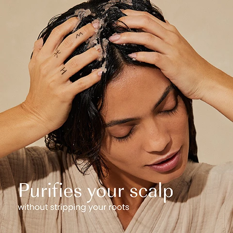 Image 1 - A person with dark hair applies a light-colored granular scalp treatment to their head, with the text Purifies your scalp without stripping your roots. Image 2 - A persons hands hold an open jar of pink granular scalp scrub with one hand scooping product, alongside the text Removes dandruff flakes, Balances scalp, Exfoliates, and the product label izil PURIFY PINK SALT DEEP CLEANSE SCALP SCRUB EXFOLIATE, PURIFY & BALANCE SCALP ROSEMARY, TEA TREE, HIMALAYAN SALT. Image 3 - A close-up of a pinkish-orange granular scrub texture with visible text that reads: 97.9% NATURAL, SLS & SLES-FREE, CRUELTY-FREE, MICROPLASTICS-FREE, FREE FROM GMOS, ALCOHOL, ARTIFICIAL COLOURS & FRAGRANCE. Image 4 - The image displays two izil Pink Salt Scalp Scrub jars, one with a white lid and brown body representing the old look, and another with a dark green lid and translucent brown body representing the new look, with the visible text reading New Look, Same formula you love, izil PINK SALT SCALP SCRUB Himalayan Pink Salt, Rosemary Oil, Tea Tree Oil, Exfoliates. Nourishes. Revitalises. and izil PURIFY PINK SALT DEEP CLEANSE SCALP SCRUB EXFOLIATE, NOURISH & BALANCE SCALP, with HIMALAYAN PINK SALT, ROSEMARY OIL, TEA TREE OIL.