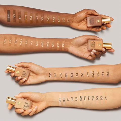 Image 1 - Four arms with varying skin tones are shown, each displaying a line of foundation swatches ranging from dark to light, with visible shade codes like 9N1, 6N1, 4W3, 2W1, and 0N1, and each hand holds a bottle labeled Estee Lauder Double Wear Stay-in-Place Makeup SPF 10. Image 2 - An Estee Lauder Double Wear foundation bottle with a gold cap is displayed on a background of various brown foundation swatches and wavy streaks, with text on the bottle that reads ESTEE LAUDER Double Wear Stay-in-Place Makeup Teint longue tenue Intransférable SPF 10, and additional text in the corner reading 24-HOUR BUILDABLE WEAR. Image 3 - A hand holds a dark amber bottle of Estee Lauder serum while another hand holds the dropper with a golden cap, from which a drop of serum is dripping, displaying the text ESTEE LAUDER Advanced Night Repair Synchronized Multi-Recovery Complex Complexe multi-réparation synchronisée on the bottle and ESTEE LAUDER on the dropper cap. Image 4 - A dark amber Estee Lauder Advanced Night Repair serum bottle with a dropper stands next to a list titled Advanced Night Repair, 1 serum, 7 benefits: which includes Reduces lines, Firms, Evens tone, Fortifies, Hydrates, Boosts radiance, Soothes, and the bottle label reads ESTEE LAUDER Advanced Night Repair Synchronized Multi-Recovery Complex Complexe multi-réparation synchronisée, with ESTÉE LAUDER also visible on the dropper cap. Image 5 - A woman with glowing skin has a dropper held by a hand applying a yellowish serum to her cheek, with the text 89% said skin felt firmer* *Consumer testing on 543 women after 4 weeks of product use. Image 6 - A brown Estee Lauder Advanced Night Repair serum bottle stands surrounded by three dishes containing ingredients, with text labels reading Exclusive Tripeptide-32, Vitamin E, Hyaluronic acid, ESTEE LAUDER, Advanced Night Repair, Synchronized Multi-Recovery Complex, Complexe multi-réparation synchronisée.
