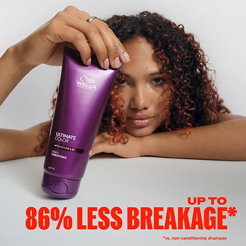 Image 1 - A woman with curly auburn hair rests her head on her arms, holding a purple tube of Wella Professionals Ultimate Color conditioner, with visible text on the tube: WELLA PROFESSIONALS ULTIMATE COLOR WITH GLYCINE & B5 STEP 2 CONDITIONER 200 ML, and overlaid red text at the bottom: UP TO 86% LESS BREAKAGE* *vs. non-conditioning shampoo. Image 2 - A before and after image shows the back of a persons head with short, red hair, split down the middle; the left side, labeled BEFORE with non-conditioning shampoo, shows duller, slightly frizzy hair, while the right side, labeled AFTER with Ultimate Color regimen, displays vibrant, smooth, and shiny hair. Image 3 - Abstract shiny purple shapes and spheres on a dark background with white text that reads: GLYCINE & METAL PURIFIER, Shield hair, offering protection from damage due to free radicals, B5, Helps to replenish & retain moisture from scalp to ends. Image 4 - A hand squeezes a wet purple conditioner bottle, dispensing a stream of white conditioner, with the text ULTIMATE COLOR, WITH GLYCINE & B5, STEP 2, CONDITIONER, 200 ML | 6.7 FL OZ on the bottle, and overlaid red text stating SMOOTH, CREAMY TEXTURE FOR POROUS STRANDS. Image 5 - A dark purple, wet Wella Professionals Ultimate Color conditioner tube stands against a red and black background, with visible text WELLA PROFESSIONALS, ULTIMATE COLOR, WITH GLYCINE & B5, STEP 2 CONDITIONER, 200 ML 6.7 FL OZ, Moisture, Anti-porosity, Colour Safe. Image 6 - A person from behind combs wet, light blonde hair with a black comb, next to text describing hair care steps: 1 Apply to clean, damp hair lengths and ends. 2 Leave on for 30sec - 3min. 3 Rinse thoroughly. Image 7 - Three light pink flowers with orange centers are set against a dark purple background with leaves, and the visible text reads FRAGRANCE Unique, fruity & florential fragrance with top notes of orange zest, apple & leafy green. Image 8 - Four purple Wella Ultimate Color hair care products are arranged from left to right: a shampoo bottle, a conditioner tube, a leave-in mask pump bottle, and a shine spray bottle, and the visible text includes COLOUR VIBRANCY FOR UP TO 10 WEEKS* UP TO 4X MORE RESISTANCE TO BREAKAGE, with each product labeled Wella Professionals Ultimate Color with Glycine & B5, and specific labels read STEP 1 Cleanse STEP 1 Sulfate-Free Shampoo 250 ML 8.4 FL OZ, STEP 2 Condition STEP 2 Conditioner 200 ML 6.7 FL OZ, STEP 3 INTENSE Leave-In Mask STEP 3 Intense Miracle Leave-in Mask 95 ML 3.2 FL OZ, STEP 4 Finish STEP 4 Shine Spray 95 ML 3.2 FL OZ, and the disclaimer *With regular use of ULTIMATE COLOR regimen from salon to home.