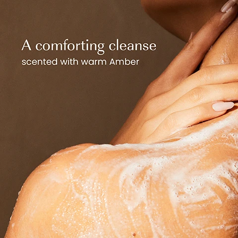 Image 1 - A persons shoulder and upper arm are covered in white soap lather, with a hand gently resting on the shoulder, above which is the text A comforting cleanse scented with warm Amber. Image 2 - A bottle of Izil Amber Cleansing Shower Gel stands on a stone platform with a ginger root on the left and a piece of amber on the right, displaying the text izil AMBER CLEANSING SHOWER GEL CLEANSE & HYDRATE Ginger Extract Vegetable Glycerin O GEL DOUCHE NETTOYANT À LAMBRE من المستخلصات النباتية و العنبر GINGER EXTRACT VEGETABLE GLYCERIN. Image 3 - A hand holds a light-toned izil Amber Cleansing Shower Gel bottle against a background of a shoulder with foam, displaying text that reads: Supports healthy microbiome, Cleanses, Hydrates, izil, AMBER CLEANSING SHOWER GEL, CLEANSE & HYDRATE, Ginger Extract. Vegetable Glycerin, GEL DOUCHE NETTOYANT À LAMBRE, and جل الاستحمام برائحة العنبر. Image 4 - A close-up of golden yellow liquid filled with bubbles and a stream pouring in from the top right, displaying the text 96.9% NATURAL, SULPHATE-FREE, CRUELTY-FREE, FREE FROM GMOs, ALCOHOL, ARTIFICIAL COLOURS & FRAGRANCE. Image 5 - Five Izil Amber skincare products are lined up on stone blocks against a textured brown background, with loose ginger root and amber pieces, and visible text includes the overhead labels Cleanse, Exfoliate, Moisturise, Nourish, Refresh, and product labels that read izil AMBER CLEANSING SHOWERGEL CLEANSE & HYDRATE WITH GINGER, AMBER & ARGAN 100% CLEAN PARABEN FREE, SILICONE FREE NATURAL FRAGRANCE; izil AMBER EXFOLIATING BODY SCRUB WITH GINGER, AMBER & ARGAN 100% CLEAN PARABEN FREE, SILICONE FREE NATURAL FRAGRANCE; izil AMBER MOISTURISING BODY LOTION MOISTURISE & SMOOTH WITH GINGER, AMBER & ARGAN 100% CLEAN PARABEN FREE, SILICONE FREE NATURAL FRAGRANCE; izil AMBER & NOURISHING BODY OIL NOURISH & RADIATE WITH GINGER, AMBER & ARGAN 100% CLEAN PARABEN FREE, SILICONE FREE NATURAL FRAGRANCE; and izil AMBER & REFRESHING PERFUME MIST HYDRATE & REFRESH WITH GINGER, AMBER & ARGAN 100% CLEAN PARABEN FREE, SILICONE FREE NATURAL FRAGRANCE. Image 6 - The image displays two izil shower gel bottles, an old amber bottle with a black cap on the left featuring an illustration of a building and a new light beige bottle with a lighter beige cap on the right, highlighting a packaging change; the visible text on the image includes New Look, Same formula you love, and on the old bottle izil, Sensual Nights in Marrakech, Shower Cleansing, Made of moroccan ingredients, Argan oil, Ginger extract, Vegetable Glycerin, Gel Douche Nettoyant & Hydratant, à lhuile dargan, extrait de gingembre, glycérine végétale, 250ml e / 8.4 fl.oz., while the new bottle shows izil, AMBER CLEANSING SHOWER GEL, CLEANSE & HYDRATE, Ginger extract, Vegetable Glycerin, GEL DOUCHE NETTOYANT & LAMBRE, extrait de gingembre, glycérine végétale, 250ml e / 8.4 fl.oz.