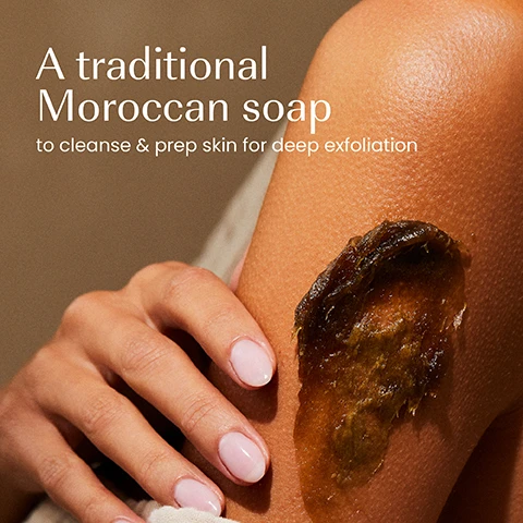Image 1 - A persons arm and shoulder with a dark, thick exfoliating soap applied, while a hand with light pink nails rests nearby, alongside the text A traditional Moroccan soap to cleanse & prep skin for deep exfoliation. Image 2 - A hand holds a dark blue jar of izil Moroccan Beldi Black Soap, a textured black scrub, with background text reading Removes dead skin, Nourishes, Hydrates. The jar label also displays NOURISH, HYDRATE & PURIFY, Eucalyptus Oil . Argan Oil . Olive Oil, SAVON NOIR BELDI DU MAROC, and الصابون الأسود البلدي المغربي. Image 3 - A dark, textured background with white text listing product attributes: 88% NATURAL, HALAL, CRUELTY-FREE, GMOS, ALCOHOL, ARTIFICIAL COLOUR & FRAGRANCE, PARABENS, SULPHATES. Image 4 - The image displays a product packaging redesign with two jars separated by a vertical line, showing the old look on the left and the new look on the right, with the text New Look, Same formula you love; the old jar label reads izil, MOROCCAN SOAP - EUCALYPTUS, Argan Oil - Olive Oil - Eucalyptus, Cleanses - Purifies - Nourishes, and the new jar label reads izil, MOROCCAN BELDI BLACK SOAP, NOURISH, HYDRATE & PURIFY, Eucalyptus Oil, Argan Oil, Olive Oil.