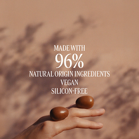 Image 1 - A textured background of swirling light beige and brown creamy substances with the text Formulated With Shea Butter. Image 2 - A hand holds two smooth, brown, oval objects against a peach background with soft shadows, with text that reads Made with 96% Natural Origin Ingredients Vegan Silicon-Free.
