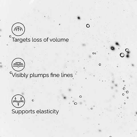 Image 2 - Three sets of icons and text are displayed on a bubbly, translucent background: an icon with three upward arrows next to Targets loss of volume, an icon with wavy lines next to Visibly plumps fine lines, and an icon with arrows compressing and bouncing next to Supports elasticity. Image 3 - A close-up of a persons face with a hand touching their cheek, next to three labels that read Targets Volume, Plumps Fine Lines, and Supports Elasticity. Image 4 - A clear liquid with visible particles is shown next to text listing Key ingredients in Volufiline 92% + Pal-Isoleucine 1%: Volufiline™ Targets areas prone to volume loss, and Pal-Isoleucine Visibly plumps fine lines and wrinkles. Image 5 - The image displays a skincare regimen featuring four The Ordinary products: a Squalane Cleanser, a Hyaluronic Acid 2% + B5 serum, a Volufiline* 92% + Pal-Isoleucine 1% serum, and a Natural Moisturizing Factors + HA moisturizer, with the heading A regimen for plumped, hydrated skin, and further text describing each step: PREP ●○○ Squalane Cleanser Cleanses skin of makeup and impurities. TREAT ●●○ Hyaluronic Acid 2% + B5 Hydrates and plumps fine lines. Volufiline* 92% + Pal-Isoleucine 1% Targets loss of volume. SEAL ●●● Natural Moisturizing Factors + HA Surface hydrator to strengthen the skin’s barrier. Image 6 - Close-up of a person with dark skin applying a white cream under their eye, highlighted by a dashed circle, with text that reads Just Where You Need It. Apply morning and evening after moisturizer to the under-eye area, temples and around the cheeks and smile lines.