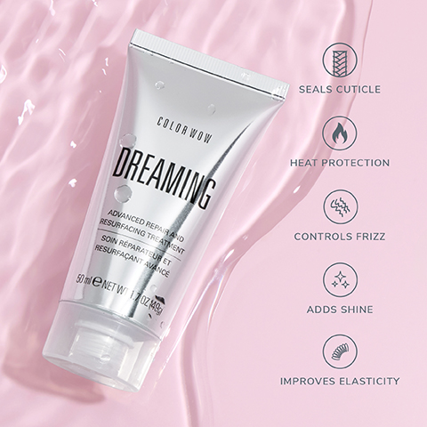 A silver tube of Color Wow Dreaming Advanced Repair and Resurfacing Treatment, also labeled Soin Réparateur et Resurfaçant Avancé, 50 ml e NET WT 1.7 OZ (49 g), rests on a wavy pink background with five icons to its right describing benefits: Seals Cuticle, Heat Protection, Controls Frizz, Adds Shine, and Improves Elasticity.