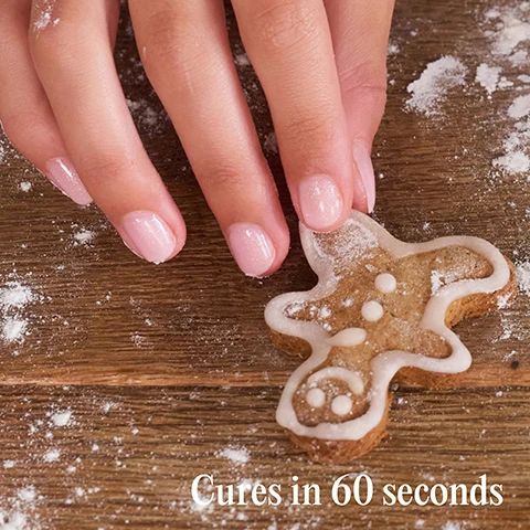 Image 1 - A hand with pink sparkly nails touches a gingerbread man cookie decorated with white icing on a wooden surface dusted with flour, with text Cures in 60 seconds. Image 2 - Two hands with light pink shimmery nail polish hold a gingerbread man cookie decorated with white icing, with the text Chip-free for up to 3 weeks. Image 3 - A diagram illustrates a four-step process for nail application, with each step showing an icon depicting the action and a corresponding text description, reading Step by step 01 PREP File nails to shape and use a Mylee Buffing Block* to gently remove shine from the nail plate. Wipe your nails with a dash of Mylee 2-in-1 Nail Prep & Wipe* on a Mylee Lint Free Wipe* to remove any oils. If you’re prone to lifting, apply the Mylee Dehydrator* followed by the Mylee Acid-Free Primer*. mylee 02 BASE Apply a thin layer of your chosen Mylee Base Coat* and Apply a thin layer of Mylee Clear 5-in-1 Builder Gel* to your nails and cure for 60 seconds using a Mylee LED Lamp* to lock it in. 60 sec 03 COLOUR To strengthen, brush on 2-4 very thin layers of Mylee 5-in-1 Builder Gel, curing each layer for 60 seconds. To build ex-tensions of up to 1cm, attach a Mylee Paper Nail Form* and brush the Builder Gel over the entire nail, extending the tip, and cure for 60 seconds. Repeat this step to build a strong extension. 60 sec 04 FINISH Seal the deal with a Mylee Top Coat* and cure for 60 sec-onds. If using the regular Mylee Top Coat, remove the tacky layer with 2-in-1 Nail Prep & Wipe on a Lint Free Wipe. Alternatively skip this step and use a Mylee No-Wipe Top Coat*! Wash your hands, apply Mylee Nail & Cuticle Oil*, moisturise, and enjoy your salon-quality mani for up to 3 weeks! *Product sold separately.