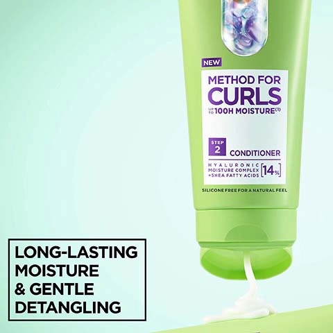 Image 2 - A light green tube of conditioner is squeezed, with white conditioner dispensing from the opening, and the visible text on the tube reads NEW METHOD FOR CURLS UP TO 100H MOISTURE (1) STEP 2 CONDITIONER HYALURONIC MOISTURE COMPLEX + SHEA FATTY ACIDS [14%] SILICONE FREE FOR A NATURAL FEEL, alongside a text box in the bottom left stating LONG-LASTING MOISTURE & GENTLE DETANGLING. Image 3 - A smiling woman with voluminous curly brown hair rests her hand on her cheek, with text overlay saying UP TO 5X EASIER DETANGLING.* *instrumental test vs non conditioning shampoo. Image 4 - Three sets of before and after images show curly hair in dark brown, blonde, and reddish brown looking more defined and moisturized after treatment, with additional text that reads CURLS FEEL MOISTURISED FOR UP TO 72H* and *instrumental test, after use of shampoo and mask. Image 5 - The image shows a creamy white texture with wavy lines, and a text box reads NO silicones for a natural feel NO artificial colourants. Image 6 - A light green Garnier Method for Curls 100H Moisture conditioner tube is displayed on a light green background, alongside Cruelty Free International and Vegan Formula badges, with additional text reading No animal-derived ingredients or by-products, NEW, STEP 2, HYALURONIC MOISTURE COMPLEX + SHEA FATTY ACIDS, 14%, and SILICONE FREE FOR A NATURAL FEEL.