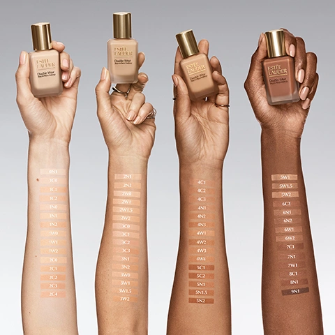 Image 1 - Four arms with varying skin tones hold Estee Lauder Double Wear Stay-in-Place Makeup bottles, with foundation shade swatches on their forearms labeled 1N1, 1C0, 1C1, 1C2, 1N0, 1N2, 1N3, 1W0, 1W1, 1W2, 2C0, 2C1, 2C2, 2C3, 2C4, 2N1, 2N2, 2W0, 2W1, 2W1.5, 2W2, 3C0, 3C1, 3C2, 3C3, 3N1, 3N2, 3W0, 3W1.5, 3W2, 4C1, 4C2, 4C3, 4N1, 4N2, 4N3, 4W1, 4W2, 4W3, 4W4, 5C1, 5C2, 5N1, 5N1.5, 5N2, 5W1, 5W1.5, 5W2, 6C2, 6N1, 6N2, 6W1, 6W2, 7C1, 7N1, 8C1, 8N1, 9N1. Image 10 - A line of four Estee Lauder Double Wear cosmetic products is shown, including visible text: ESTEE LAUDER Double Wear Smooth & Blur primer Base de teint effet lissé et flouté naturel 1. Prime, ESTEE LAUDER Double Wear Stay-in-Place Makeup 2. Perfect, ESTEE LAUDER Double Wear Stay-in-Place Concealer Correcteur anti-cernes 3. Conceal, 4. Set. Image 2 - A side-by-side comparison of two Estee Lauder Double Wear Stay-in-Place Makeup foundation bottles, with the left bottle representing THE ORIGINAL FORMULA, which has Teint longue tenue intransférable SPF 10 and offers Medium-to-full coverage, 24HR colour-true wear, 8HR oil control, and 60 natural-matte shades; and the right bottle labeled NEW, representing the NOW MADE FOR MORE formula, which is Lightweight & buildable, 36HR colour-true wear, 36HR oil control & hydration, and has the Same shade, better formula. Image 3 - A womans face is split vertically down the middle, showing a before view on the left with natural skin and an after view on the right with smoother, more even-toned skin, with the text BEFORE visible on the bottom left and AFTER on the bottom right. Image 4 - Ten Estée Lauder foundation bottles are arranged in a line, showing a range of shades from dark to light, on a reflective surface, with the text 60 shades. One made for you. and The NEW Double Wear. Image 5 - A bottle of Estee Lauder Double Wear Stay-in-Place Makeup foundation with a gold cap, partially covered by sheer fabric, sits against a light background with text that reads 36HR Long Wear Lightweight Breathable Moves with you. Image 6 - The image shows a four-panel grid of womens faces, each demonstrating a before-and-after comparison of a skin concern with visible text reading Target Visible Skin Concerns, Bare Skin, Double Wear Skin, Redness, Dark Circles, Oil & Shine, Uneven Skin Tone. Image 7 - A persons face with dots of foundation applied to her forehead, cheek, and chin, with a finger dabbing more on her cheek, next to the text The Perfect Application 1. Shake 2. Dot 3. Blend. Image 8 - A bottle of Estée Lauder Double Wear Stay-in-Place Makeup with a gold cap is shown angled on top of streaks of liquid foundation in varying shades from dark brown to light beige, with a bulleted list of product features on the left side of the image. ESTEE LAUDER Double Wear Stay-in-Place Makeup More buildable, breathable Weightless, light-as-air Skin-like feel Controls oil Hydrates. Image 9 - A bottle of Estée Lauder Double Wear Stay-in-Place Makeup foundation with a gold cap is shown next to a piece of yellow-green seaweed and a swipe of light beige product, with text that reads 36HR Oil Control + Instant Hydration With algae extract, niacinamide & hyaluronic acid ESTEE LAUDER Double Wear Stay-in-Place Makeup.