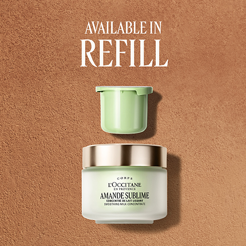 A jar of LOCCITANE Amande Sublime cream with a gold lid and a green refill pod above it, against a brown background, with the text AVAILABLE IN REFILL, CORPS LOCCITANE EN PROVENCE AMANDE SUBLIME CONCENTRÉ DE LAIT LISSANT SMOOTHING MILK CONCENTRATE.