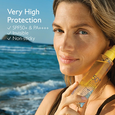 Image 1 - A woman with long hair and blue eyes smiles while holding a yellow bottle of Caudalie sunscreen on a beach with the ocean in the background, with visible text that reads Very High Protection, SPF50+ & PA++++, Invisible, Non-sticky, and on the bottle CAUDALIE 50+ Eau Solaire Très Haute Protection Visage, Corps & Cheveux, Invisible, Non grasse, Waterproof, Sun Type II to VI. Image 10 - Blue outline illustration of a bottle with its cap removed, on a yellow background, with text that reads How to recycle the Sun water SPF50+. Remove the pump and the cap, and recycle them with Terracycle at a Caudalie Boutique Spa. Recycle the bottle in the recycling bin. Image 2 - A smiling woman in a bikini top holds a happy blonde child on a beach, with text Suitable for children and babies. Image 3 - A person wearing a brown bikini top and gold necklace holds a yellow-capped sunscreen spray bottle with a blurred blue water background, with overlaid text that reads Face, body & hair Light & non-sticky, and text on the bottle reading Caudalie Paris, SPF 50+ PA++++, Haute Protection Corps & Cheveux, Water-resistant, 150 mL - 5 fl. oz. Image 4 - A hand holds a tall yellow Caudalie sunscreen spray bottle against a blurred ocean background, with motion blur indicating the bottle is being shaken, displaying text Bi-phase formula Shake well before use and on the bottle CAUDALIE PARIS 50+ PA++++ SPF UVA+UVB Very High Protection Invisible Water Resistant Face Body Hair 150 ml. Image 5 - A yellow Caudalie sunscreen spray bottle, labeled CollagenSkin Protect™ Antioxidant, preserve the skins collagen, CAUDALIE PARIS, 50+ PA++++ SPF UVB UVA, Eau Solaire Très Haute Protection Invisible. Résiste à leau. Visage, Corps, Cheveux. Very High Protection Sun Water Invisible. Water-resistant. Face, Body, Hair. Adultes, enfants, bébés. Adults, children, babies. 150 mL - 5 Fl. Oz., stands in the sand on a beach with blue water in the background, alongside text reading 4 organic sunscreen filters Optimal broad-spectrum protection against UVA and UVB rays. Image 6 - A smiling woman with wet hair and a dollop of white cream on her cheek, against a sunny beach background, with the text Water-resistant. Image 7 - A shimmery golden Caudalie sunscreen spray bottle with a yellow cap sits on brown rocks next to a bunch of dark grapes and a white-fleshed coconut half, with text reading New addictive sunny fragrance, CAUDALIE, 50+, Eau Solaire Très Haute Protection Visage Corps Cheveux, Very High Protection Sun Water Face Body Hair. Image 8 - The image displays two Caudalie SPF 50+ sun protection spray bottles: on the left, a clear bottle against a white background with text Very High Protection Sun Water, Benefit Invisible very high protection, Light watery Texture, Perfect for Face, body & hair; on the right, an amber bottle against a yellow background with text High Protection Glow Oil, Benefit High Protection & radiant tan, Oil with a satin finish texture, Perfect for Face, body & hair. Image 9 - A range of Caudalie sun protection products, including yellow tubes, spray bottles, a stick, and clear and brown bottles, arranged on a light-colored ground against a vibrant blue wall, with visible text Suncare collection, Face protection, Face & body protection, Caudalie, SPF 30, SPF 50, and SPF 50+.