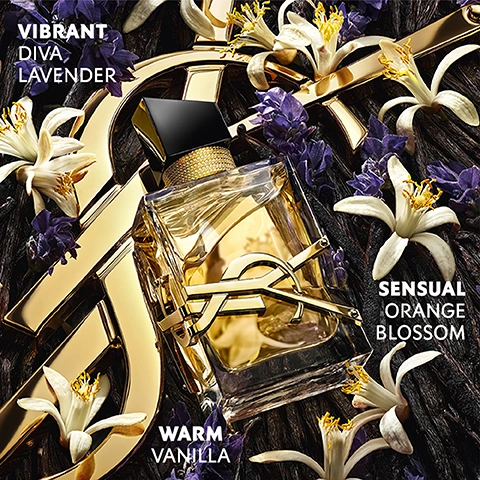 A gold and clear YSL Libre perfume bottle sits among purple lavender florets, white orange blossoms, and dark vanilla bean pods, with text that reads Vibrant Diva Lavender, Sensual Orange Blossom, Warm Vanilla.