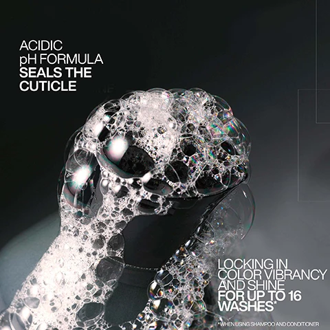 Image 1 - A close-up shot of a mass of white and iridescent soap bubbles on a dark, reflective surface, with the text Acidic pH Formula Seals the Cuticle and Locking in Color Vibrancy and Shine for Up to 16 Washes* When Using Shampoo and Conditioner. Image 2 - A black bottle with an open flip-top cap has a dollop of white creamy product emerging from its opening, with text reading ACIDIC pH FORMULA SEALS THE CUTICLE and LOCKING IN COLOR VIBRANCY AND SHINE FOR UP TO 16 WASHES*. *WHEN USING SHAMPOO AND CONDITIONER. Image 3 - A black pump bottle with a pink label for Redken Naked Gloss Lightweight Shine Oil stands on a dark textured surface, displaying text including REDKEN 5TH AVENUE NYC, naked gloss, lightweight shine oil, shine & color vibrancy, for colored & non-colored hair, FATTY ACIDS+, 18% SHINE COMPLEX, SALON EXPERT CONCENTRATION, 3.4 fl oz 100 ml, and listing benefits UP TO 130% MORE SHINE*, UP TO 80% REDUCTION IN FRIZZ**, HEAT PROTECTION UP TO 230°C, NAKED, LIGHTWEIGHT FEEL, with disclaimers * INSTRUMENTAL TEST VS. UNWAS-HED HAIR ** INSTRUMENTAL TEST VS. NON-CONDITIONING SHAMPOO. Image 4 - A split image shows a womans long, wavy brown hair before and after treatment, with the hair on the right appearing more vibrant and shiny, alongside the text: BEFORE AFTER BOOST COLOR VIBRANCY FOR UP TO 16 WASHES USING ACIDIC COLOR GLOSS SHAMPOO & CONDITIONER. Image 5 - A split image of a persons hair, showing dull, frizzy brown hair on the left before treatment and shiny, smooth brown hair on the right after treatment, with visible text BEFORE, AFTER*, and *ONE USE OF ACIDIC COLOR GLOSS SYSTEM. Image 6 - A split image shows a womans long dark hair from the back before and after treatment, with the left side showing duller hair and the right side showing significantly shinier and smoother hair, with text that reads BEFORE, AFTER*, and *USE OF ACIDIC COLOR GLOSS SHAMPOO, CONDITIONER, AND NAKED GLOSS OIL. Image 7 - A close-up shows white creamy streaks of a product with the text SHINE & COLOR CARE CONDITIONER. Image 8 - A black pump bottle of Redken Naked Gloss Lightweight Shine Oil with a pink label, surrounded by clear liquid on a dark gradient background, with the visible text SHINE WITH A NAKED FEEL and on the bottle REDKEN 5TH AVENUE NYC naked gloss lightweight shine oil huile de brillance légère shine & color vibrancy brillance et éclat de la couleur pour: for: colored & non-colored hair cheveux colorés et non colorés FATTY ACIDS + 18% conditioning complex SALON EXPERT CONCENTRATION. Image 9 - A persons hands are shown, one squeezing a black Redken bottle with a pink label to dispense a clear liquid into the other palm, displaying the product REDKEN Acidic Glaze pH balancing shine treatment 18% Glaze Complex 3.4 fl oz / 100 ml and the usage instruction START WITH 1 PUMP, ADD MORE AS NEEDED.Image 10 - A woman with long, dark, straight hair is shown from the back as a hand combs through a section, making it appear smoother and shinier, with overlaying text that says FORMULATED WITH FATTY ACIDS & OMEGA-9S TO ENHANCE SHINE, PROTECT COLOR VIBRANCY, AND CONDITION HAIR, and Redken Labs visible on the side. Image 11 - Four black Redken hair product bottles with pink labels, specifically a shampoo, conditioner, spray, and pump oil, are arranged on a light surface, showing the text GLOSSY HAIR ROUTINE, SHAMPOO, CONDITIONER, LEAVE-IN, OIL, and individual bottle labels for Redken Acidic Color Gloss gentle color shampoo, Redken Acidic Color Gloss conditioner, Redken Acidic Color Gloss heat protection treatment, and Redken Naked Gloss lightweight shine oil.