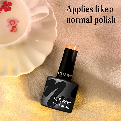 Image 1 - A black bottle of Mylee Gel Polish with an orange cap rests on a beige fabric surface next to a white teacup with small flowers, and text reads Applies like a normal polish Mylee GEL POLISH. Image 2 - A hand with iridescent peach and green nail polish holds a ripe peach, with the visible text Chip-free for up to 3 weeks. Image 3 - A hand with shimmery yellow-green nail polish holds dried spherical flowers against a textured pink background, with the text Cures in 60 seconds. Image 4 - A black Mylee gel polish bottle with an orange cap is displayed next to three icons that read CRUELTY-FREE, VEGAN, and HEMA-FREE. Image 5 - A black Mylee nail polish bottle with a red cap is open, showing the applicator brush dripping red polish, and a diagram lists features: Lasts up to 3 weeks, Cures in 30-60 seconds, Hema-free, Applies like normal polish, No dry time-cures under LED lamp, Vegan. Image 6 - The image shows a black Mylee gel polish bottle with iridescent orange-gold polish spilling out and on an applicator brush, alongside a light green circle containing text; the visible text in the image includes m y l e e on the brush handle, m y l e e GEL POLISH on the bottle, and Iridescent in the green circle. Image 7 - An infographic displays a four-step process for gel nail polish application, showing illustrations of a hand having nails prepped, a base coat applied and cured, a color coat applied and cured, and a finished nail being wiped, with the visible text Step-by-step. PREP. mylee. File nails to shape and use a Mylee Buffing Block* to gently remove shine from the nail plate. Wipe your nails with a dash of Mylee 2-in-1 Nail Prep & Wipe* on a Lint Free Wipe* to remove any oils. If youre prone to lifting, apply the Mylee Dehydrator* followed by the Mylee Acid-Free Primer*. BASE. 60 secs. Apply a thin layer of your chosen Mylee Base Coat* and cure for 60 seconds using a Mylee LED Lamp*. COLOUR. 60 secs. Brush on your favourite Mylee Gel Polish shade and cure for 60 seconds. Build up the opacity in thin coats, curing each layer for a smooth, even finish. Dont forget to cap the free edge by running some polish along the tip of your nail. FINISH. Seal the deal with a Mylee Top Coat* and cure for 60 seconds. If using a regular one, remove the tacky layer with 2-in-1 Nail Prep & Wipe on a Lint Free Wipe. Alternatively skip this step and use a Mylee No-Wipe Top Coat*! Wash your hands, apply Mylee Nail & Cuticle Oil*, moisturise, and enjoy your salon-quality mani for up to 3 weeks! *Product sold separately.