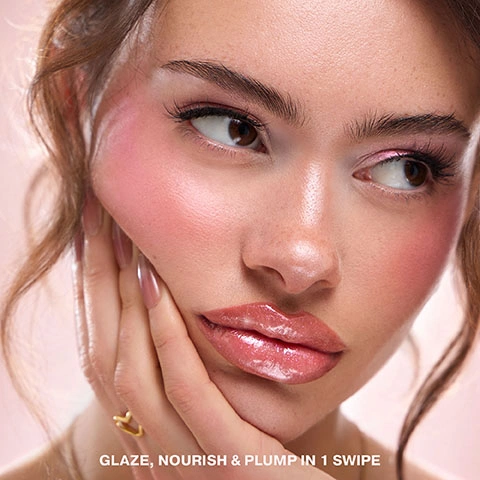 Image 3 - A close-up of a woman with pink blush and glossy pink lips, with her hand resting on her jawline, reads GLAZE, NOURISH & PLUMP IN 1 SWIPE. Image 4 - A pink tube of Iconic London Butter Glaze Beurre Givré Vanilla Sugar Lip Balm Baume à Lèvres 15ml e / 0.47 US FL. OZ rests on whipped cream topped with a cherry, with additional text stating MAKEUP-SKINCARE HYBRID, POWERED BY PEPTIDES Visibly plump & smooth SHEA BUTTER Nourish & combat dryness VITAMIN E Antioxidant protection. Image 5 - Close up of glossy, shimmering peachy-pink lips with the text Vanilla Sugar. Image 6 - A close-up of a woman with glossy pink lips, pink blush, and pink eyeshadow, with text overlay reading WHAT IT IS: A makeup-skincare hybrid that glazes lips with a sheer tint of colour. WHAT IT DOES Locks in moisture & visibly plumps for butter-soft bouncy lips. BENEFITS Zero tingle, irritation or stickiness. Image 7 - A shimmery, light pink glaze is swiped across a white background with text that reads VANILLA SUGAR LOOK LIKE: A baby pink glaze, with a soft shimmer TASTE LIKE: A sugar donut. sweet & yummy. Image 8 - A pink tube of Iconic London Butter Glaze lip balm stands upright next to a silver dessert dish filled with whipped cream and a pink swirl on top, all resting on a reflective silver tray, accompanied by text that reads How to use: Swipe on to glaze and nourish lips, with a sheer tint of colour. For best results, apply 3x daily to maximise plumping benefits & combat dryness. Iconic London Butter Glaze Beurre Givré Vanilla Sugar Lip Balm Baume à Lèvres 7.5ml e / 0.24 fl.oz. Image 9 - A pink lip gloss tube with a shimmery pink gloss coming out of the applicator, shown above a close-up of lips coated in the same glossy pink product, with text that reads VANILLA SUGAR.