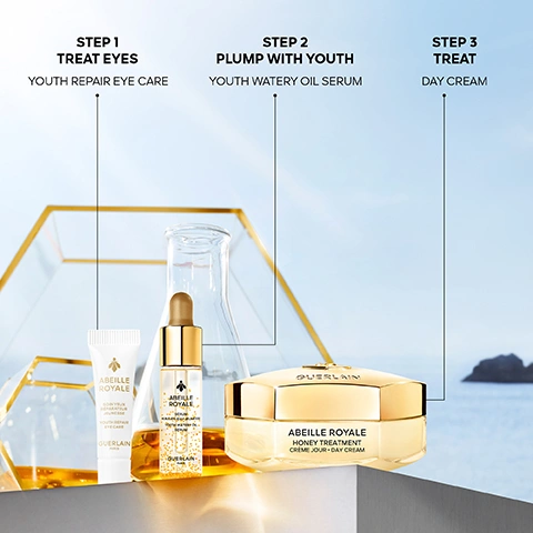 Image 1 - The image displays a three-step Guerlain Abeille Royale skincare routine on a white surface with a light gold and blue background, detailing Step 1 Treat Eyes Youth Repair Eye Care with a white tube labeled Abeille Royale Soin Yeux Réparateur Jeunesse Youth Repair Eye Care Guerlain Paris, Step 2 Plump With Youth Youth Watery Oil Serum with a golden dropper bottle labeled Abeille Royale Sérum Huile-en-Eau Jeunesse Youth Watery Oil Serum Guerlain Paris, and Step 3 Treat Day Cream with a gold hexagonal jar labeled Guerlain Abeille Royale Honey Treatment Crème Jour Day Cream. Image 2 - A woman with clear skin holds a golden eye cream jar with a bee logo near her right eye, against a light blue background, accompanied by text: ABEILLE ROYALE SOIN YEUX RÉPARATEUR JEUNESSE YOUTH REPAIR EYE CARE ALL TYPES OF WRINKLES CORRECTED¹: -43% CROWS FEET WRINKLES² -38% FROWN WRINKLES² YOUTH REPAIR EYE CARE ¹Crows feet wrinkles, frown wrinkles, undereye wrinkles, upper eye wrinkles. ²Clinical evaluation, 32 panelists, twice-daily application, results after 56 days. Image 3 - A woman with clear skin holds a golden serum bottle with a bee emblem, against a blue background, displaying text that reads AFTER 1 MONTH EVALUATED BY PANEL¹: SMOOTHER +48% FIRMER +53% MORE ELASTIC +56% YOUTH WATERY OIL SERUM, and on the bottle ABEILLE ROYALE SÉRUM HUILE-EN-EAU JEUNESSE YOUTH WATERY OIL SERUM GUERLAIN PARIS, with a footnote ¹Self-scoring, test 40 women, 2 applications per day. Image 4 - A woman with a sleek hairstyle and a hexagon earring looks directly at the viewer while holding a gold and white jar of cream with a bee emblem, labeled Guerlain Abeille Royale Honey Treatment Crème Jour Day Cream, against a blue sky background, with additional text reading DERMATOLOGICAL SCORAGE¹, WRINKLES -48%, FIRMNESS +57%, SMOOTHNESS +98%, RADIANCE +63%, DAY CREAM, and ¹Clinical test by an independent dermatologist, 33 women, Europe, once a day, results after one month. Image 5 - A beekeeper in a white suit with GUERLAIN PARIS on the back and AIGLE on their boot, walks towards the ocean carrying a smoker and tool, next to a wooden beehive marked GUERLAIN, surrounded by white wildflowers and rocky terrain at sunset, displaying the message Since 2011, Guerlain has been a patron of the Association of the Ouessant Island Brittany Black Bee Conservatory (ACANB), supporting bee protection and scientific research.