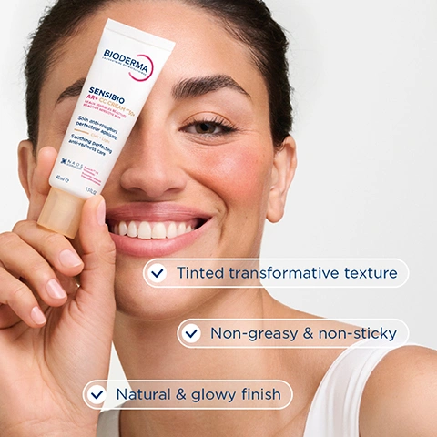 Image 1 - A smiling woman with rosy cheeks holds a cosmetic tube partially obscuring her right eye; the visible text includes BIODERMA SENSIBIO AR+ CC CREAM 40 ML SENSITIVE SKIN WITH REACTIVE REDNESS SOIN ANTI-ROUGEURS PERFECTEUR APAISANT Daily - Light SOOTHING PERFECTING ANTI-REDNESS CARE 40ml e 1.3 FL.OZ. NAOS LABORATORY on the tube, and Tinted transformative texture, Non-greasy & non-sticky, and Natural & glowy finish in accompanying text boxes. Image 2 - A woman with reddish-brown hair and visible redness on her cheeks looks forward, with overlaid text on the right stating 70% Instantly neutralises redness* and 85% Brightens the complexion*, and a small disclaimer at the bottom left reading *Clinical study, 30 subjects with reactive sensitive skin prone to redness, 28 days, % of satisfaction, France 2024. Image 3 - A close-up of a persons face with fair skin and some redness on the cheek, displaying three numbered steps: 1 Cleanse your skin with SENSIBIO AR+ MICELLAR GEL, 2 Discover SENSIBIO AR+ CC CREAM SPF50+ tinted transformative texture, 3 Apply on the morning and adjust the coverage. Image 4 - The image shows a three-step skincare routine for reactive sensitive skin prone to rosacea, featuring three Bioderma Sensibio AR+ products; visible text includes REACTIVE SENSITIVE SKIN PRONE TO ROSACEA, 1 Cleanse with Bioderma Sensibio AR+ Micellar Gel, 2 Conceal redness with Bioderma Sensibio AR+ CC Cream SPF50+ Clair Light, and 3 Soothe with Bioderma Sensibio AR+ SOS Spray. Image 5 - A microscopic view of red and pink organic tissue with a translucent circular overlay, featuring the text ROSACTIV™ 2.0 PATENTED TECHNOLOGY Targets at the source the biological mechanisms involved in different types of redness and discomfort for lasting results.