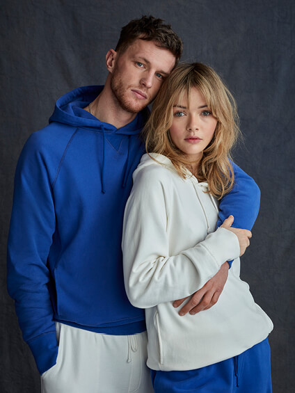 couple, one wearing blue hoodie and one wearing a white hoodie