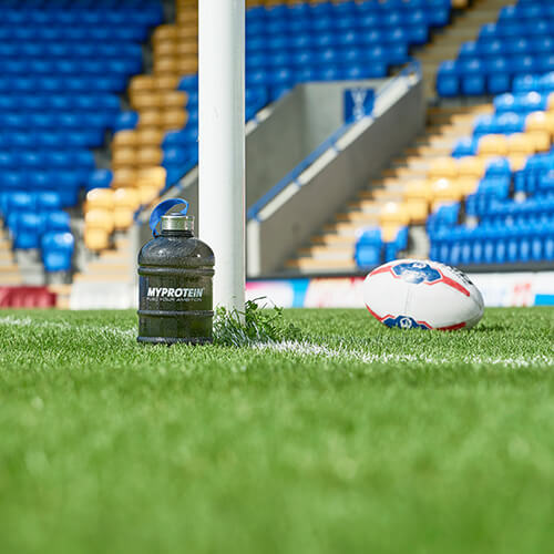 balon de rugby et bouteille myprotein avec stade en arrière-plan