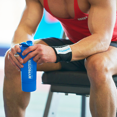 male athlete holding a protein shaker