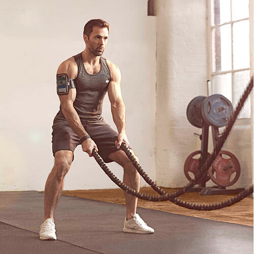 man training with battle ropes for muscle gain and strength